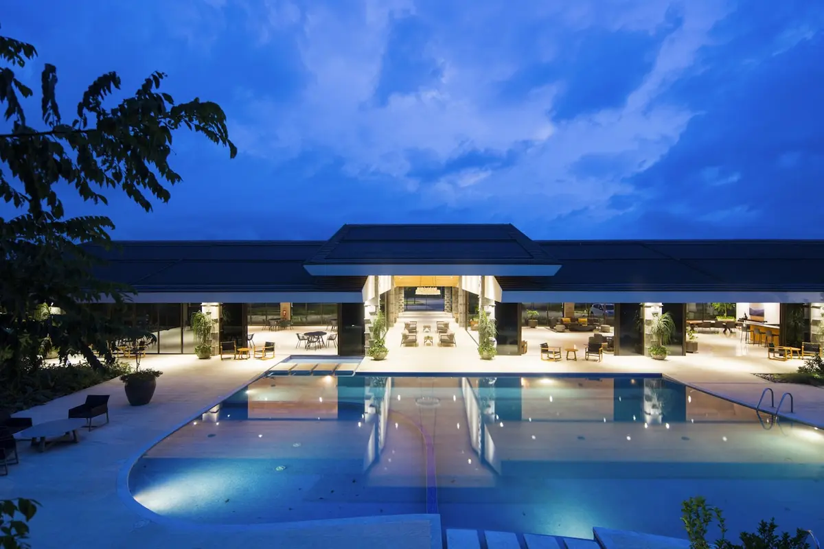 Lit hotel building and pool at blue hour